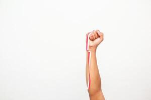 An arm raised in protest, adorned with red and white ribbon, a symbol of patriotism photo