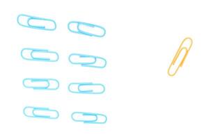 A Conceptual Image of Blue Paper Clips Grouped Apart from a Single Yellow One on White photo