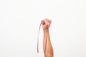 Raised Fist Holding Indonesian Flag Ribbon Symbolizing Independence Day Celebration photo