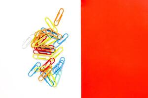 Vibrant Colored Paper Clips Scattered on White Background with Red Accent Section photo
