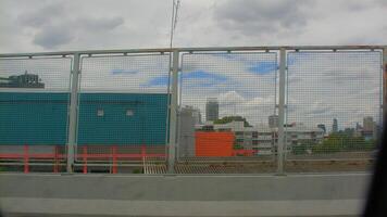 View of a highway fence with orange traffic cones and construction barriers in Bangkok, emphasizing road safety and infrastructure development. photo
