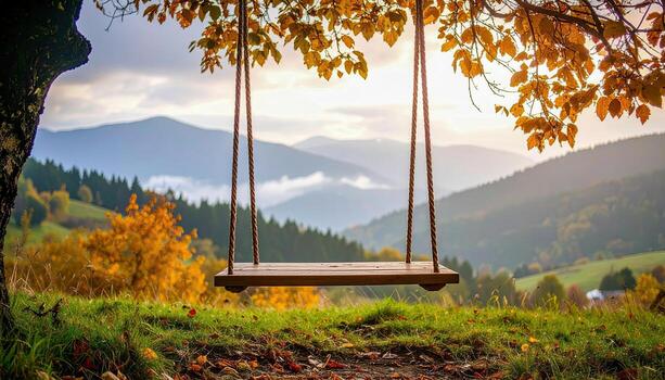 A wooden swing is suspended from a tree in a grassy field. The swing is surrounded by trees and mountains in the background, creating a serene and peaceful atmosphere photo