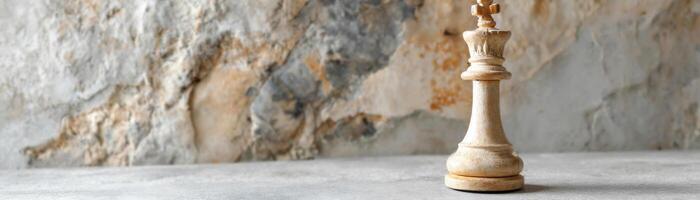 Single chess queen piece on stone surface with textured marble background photo