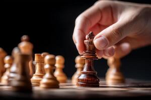 Hand moves wooden chess king on chessboard, symbolizing strategy and focus photo