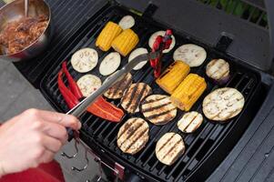 Grilled vegetables on barbecue with bell peppers and corn on the cob photo