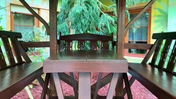 A wooden table and chairs in a garden video