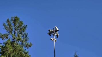 Highaltitude surveillance cameras are strategically positioned to oversee a clear blue sky and scenic trees video