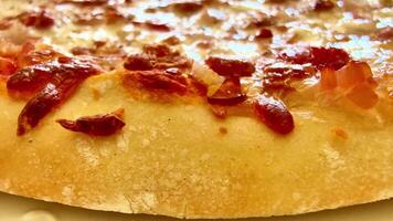 A tantalizing closeup image of a delicious, cheesy pizza generously topped with savory meat pieces galore video
