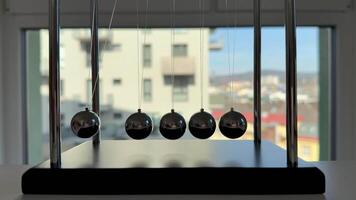 A pendulum with four balls on it video