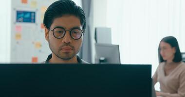 närbild Asien manlig frilans skriva prompt ai bot den app smart program nomad, spel, terminal med kodning språk, användare gränssnitt, designer, data Centrum på skrivbordet dator. video