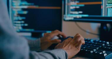 fechar-se jovem Ásia masculino freelance digitando escrever pronto ai robô isto aplicativo inteligente programa nômade, jogo, terminal com codificação linguagem, desenhista, grande dados Centro em Área de Trabalho computador dentro noite escritório. video