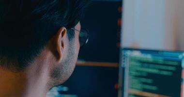 fechar-se Ásia masculino digitando escrever pronto ai robô isto aplicativo inteligente programa nômade, jogo, terminal com codificação linguagem, desenhista, grande dados Centro em Área de Trabalho computador dentro noite escritório. video