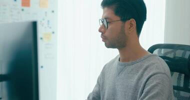 ung vuxen Asien manlig frilans glasögon skriver skriva prompt ai bot den app smart program nomad, spel, terminal med kodning, användare gränssnitt, designer, stor data Centrum på skrivbordet dator. video