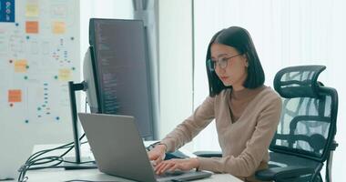 ung vuxen Asien kvinna frilans glasögon skriver skriva prompt ai bot den app smart program nomad, spel, terminal med kodning, användare gränssnitt, designer, stor data Centrum på skrivbordet dator. video