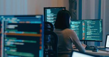 jovem Ásia fêmea freelance Óculos digitando escrever pronto ai robô isto aplicativo inteligente programa nômade, jogo, terminal com codificação linguagem, desenhista, grande dados Centro em Área de Trabalho computador dentro noite escritório. video