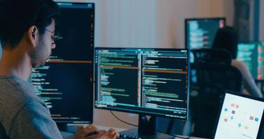 gruppo adulto Asia maschio, femmina libero professionista digitando Scrivi richiesta ai Bot esso App inteligente programma nomade, gioco, terminale con codifica linguaggio, progettista, grande dati centro su del desktop computer nel notte ufficio. video