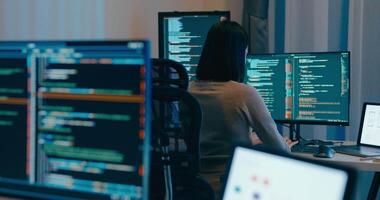 Ásia fêmea freelance digitando escrever pronto ai robô isto aplicativo inteligente programa nômade, jogo, terminal com codificação linguagem, desenhista, grande dados Centro em Área de Trabalho computador dentro noite escritório. video