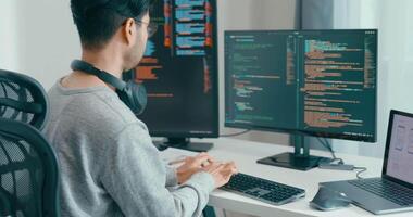 jovem Ásia masculino freelance digitando escrever pronto ai robô isto aplicativo inteligente programa nômade, jogo, terminal com codificação, do utilizador interface, desenhista, grande dados Centro em Área de Trabalho computador video