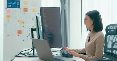 jovem Ásia fêmea freelance digitando escrever pronto ai robô isto aplicativo inteligente programa nômade, jogo, terminal com codificação, do utilizador interface, desenhista, grande dados Centro em Área de Trabalho computador. video