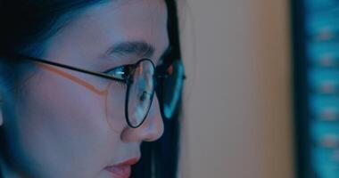 Closeup Asia female freelance eyeglasses typing write prompt AI bot IT program nomad, game, terminal with coding language, designer, big data center on desktop computer in night office. video