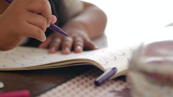 child drawing with a purple marker in a notebook video