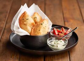 Fried Beef Empanadas with Fresh Tomato Salsa and Sour Cream Dip in plate side view of Healthy Eating photo