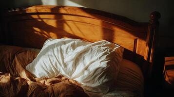 iluminado por el sol Mañana en un acogedor cama con de madera cabecera y arrugado hojas. foto