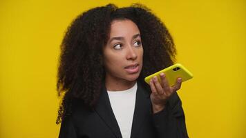 Modern professional woman recording voice message on yellow video