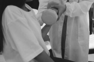 A woman in a white coat is getting her arm measured photo