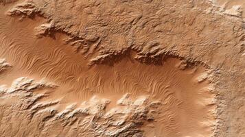 Aerial view of desert landscape with sand dunes and rocky terrain showing natural patterns and textures in warm brown tones photo