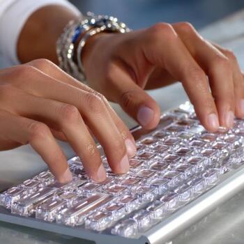 Hands typing on transparent keyboard, close up of fingers, modern technology, person working, digital device, clear keys photo