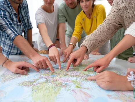 Group of people pointing at different locations on large map, planning trip together with excitement and focus photo