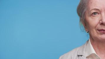 Half Face of Senior Woman on Blue Background video