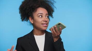 Woman Recording Voice Message on Smartphone on Blue video