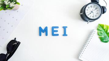 Flat lay composition with blue color foam letters spelling word Mei isolated on white background photo