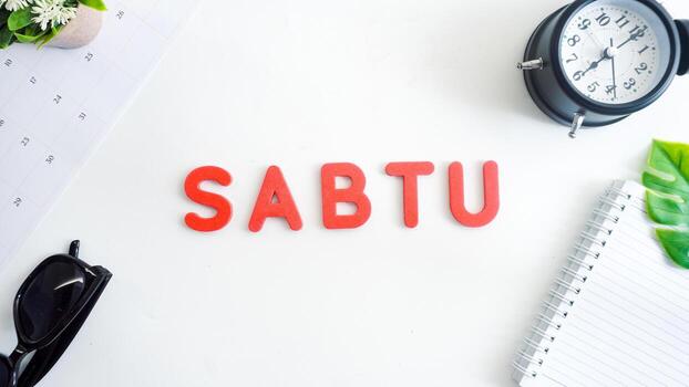 Flat lay composition with red color foam letters spelling word saturday in Indonesian, SABTU isolated on white background photo