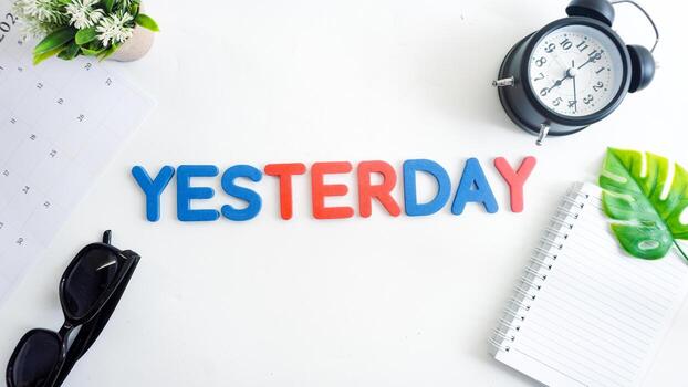 Flat lay composition with blue and red color foam letters spelling word YESTERDAY isolated on white background photo