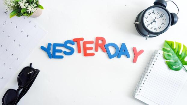 Flat lay composition with red and blue color foam letters spelling word YESTERDAY isolated on white background photo