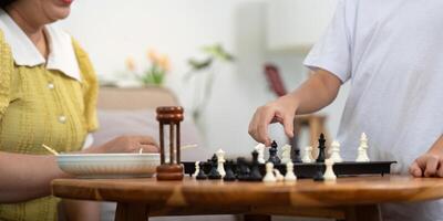 Child Strategizing Chess Move While Mother Observes photo