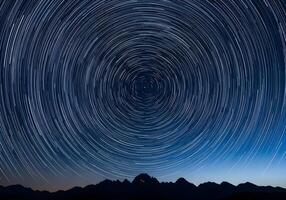 star trails over mountains in the night sky photo