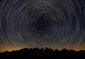 star trails over mountains at night photo