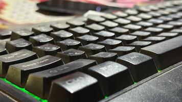 Close view shows a black dusty keyboard with green led lighting effect on display photo