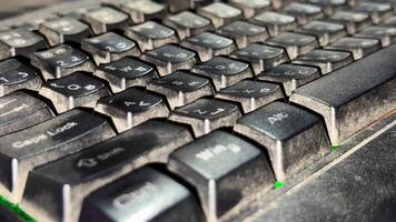 Close up shows the keys on a black, dusty computer keyboard with white letters photo