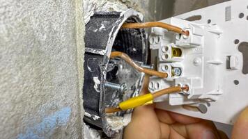 A hand deftly rewires a socket, conjuring sparks of innovation, reminiscent of International Repair Days DIY spirit photo