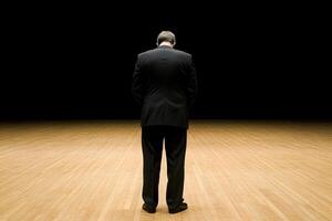 A man in a suit standing in a dark room photo