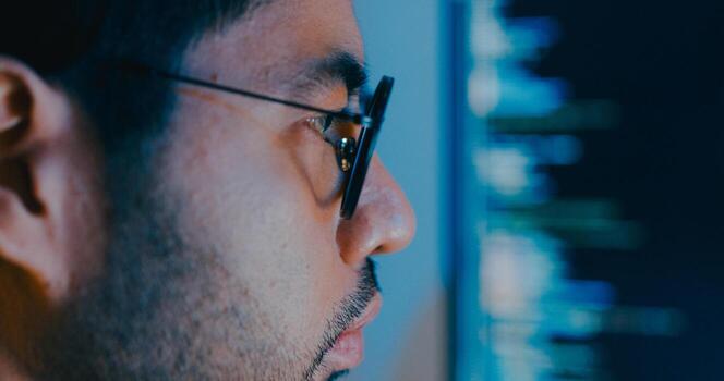 Closeup young Asia male freelance typing write prompt AI bot IT app smart program nomad, game, terminal with coding language, designer, big data center on desktop computer in night office photo