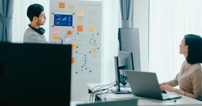 Group Asia male female software developers mentor leader manager talk strategy plan to executive write prompt AI bot IT app program nomad, game, data center. Whiteboard code photo