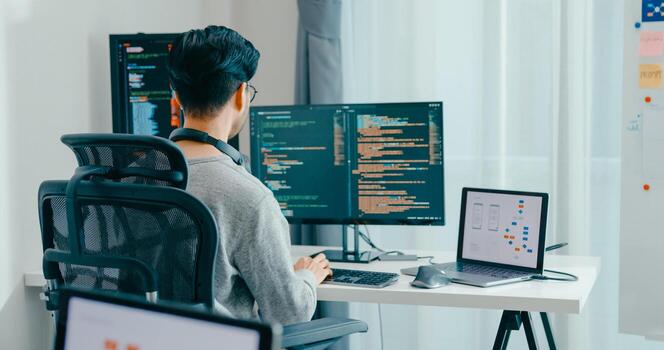 Young adult Asia male freelance typing write prompt AI bot IT app smart program nomad, game, terminal with coding, user interface, designer, big data center on desktop computer. photo