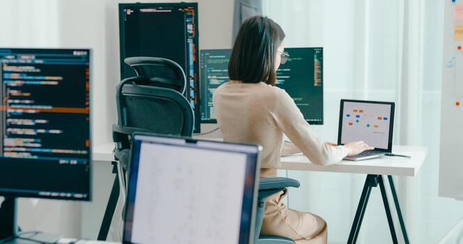 Young Asia female freelance typing write prompt AI bot IT app smart program nomad, game, terminal with coding, user interface, designer, big data center on desktop computer. photo