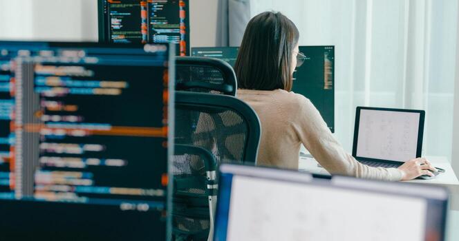 Young adult Asia female freelance typing write prompt AI bot IT app smart program nomad, game, terminal with coding, user interface, designer, big data center on desktop computer. photo